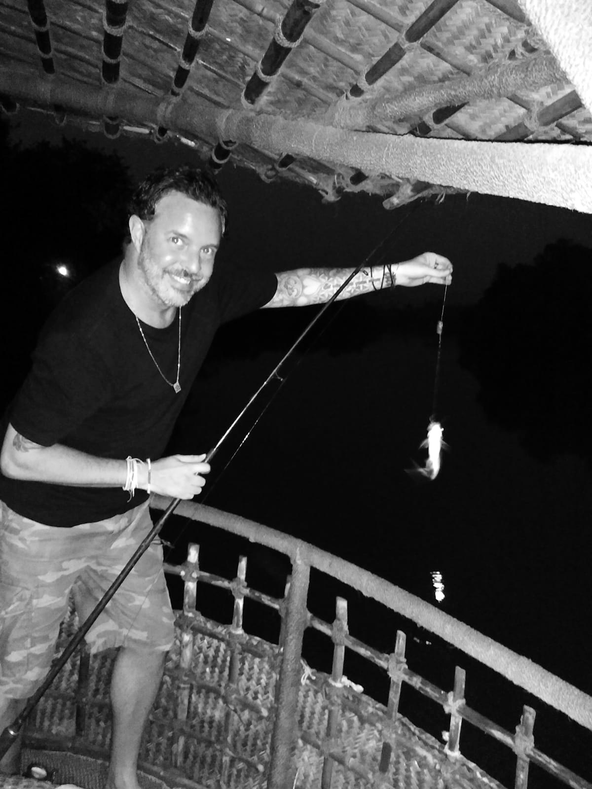 Paul Wakefield fishing from the deck of the boat at night